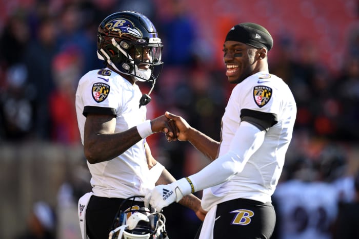 Lamar Jackson #8 and Robert Griffin III #3 of the Baltimore Ravens talking
