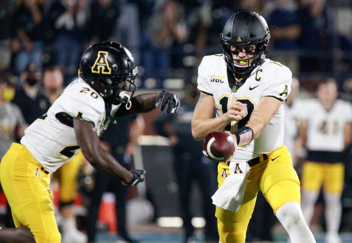 Zac Thomas hands off the football.