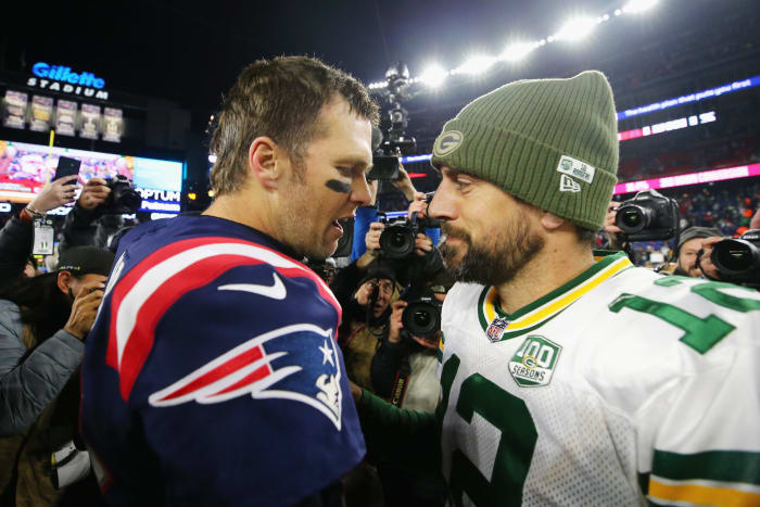 Superstar quarterbacks Tom Brady and Aaron Rodgers talk after a game.
