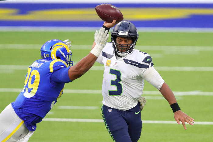 Aaron Donald prepares to hit Russell Wilson as he throws the ball.