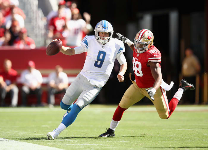 Matthew Stafford runs from a defender.