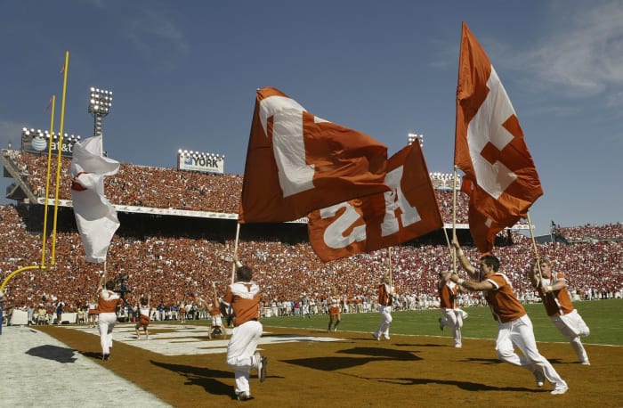 The Texas Longhorns cheerleaders holding Texas flags.