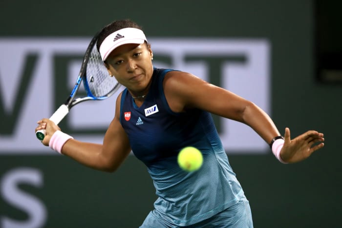 Naomi Osaka returning a shot.