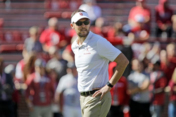 Lincoln Riley watching his players warm up before an Oklahoma football game.