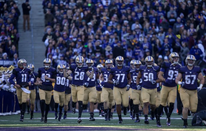 Washington football players take the field.