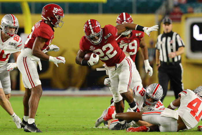 Alabama football RB Najee Harris escapes a tackle.