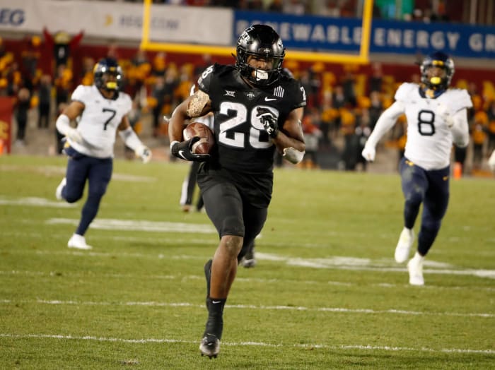 Breece Hall runs away from the defense.