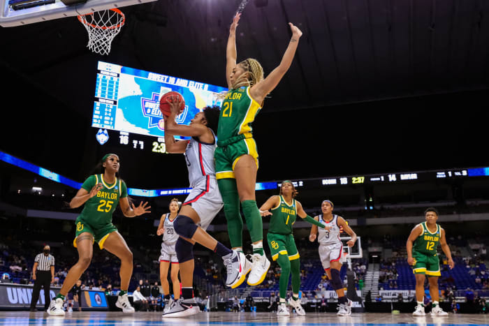 Christyn Williams #13 of the UConn Huskies drives to the basket ahead of DiJonai Carrington #21 of the Baylor Lady Bears