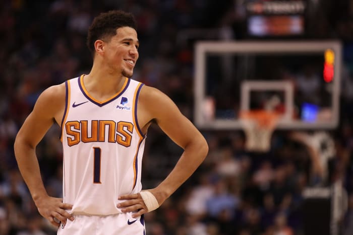 A closeup of Devin Booker smiling during a game.