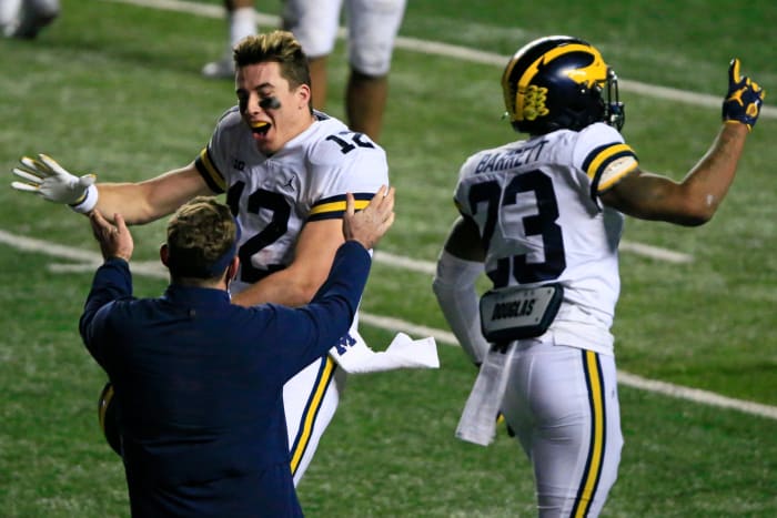 Michigan quarterback Cade McNamara celebrates on the field after a win.