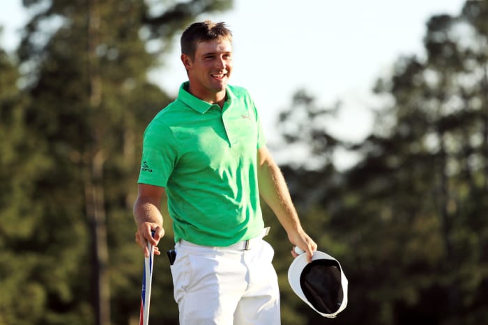 Bryson DeChambeau taking his hat off on the golf course.