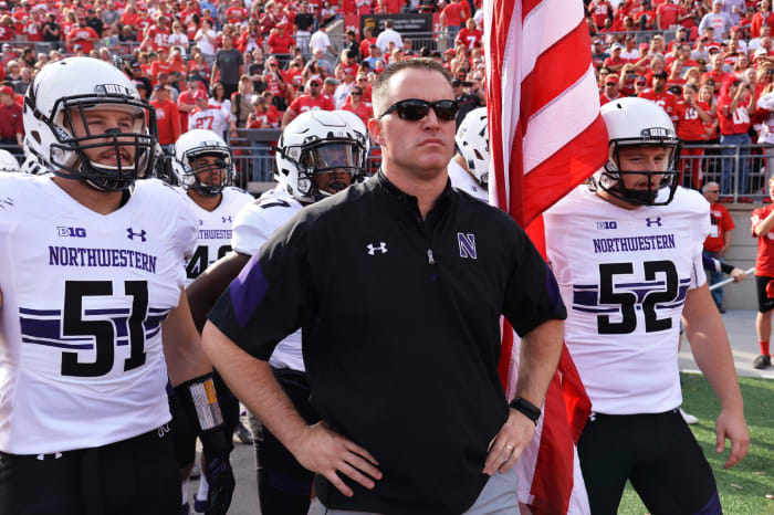 Northwestern coach Pat Fitzgerald leading his team onto the field.