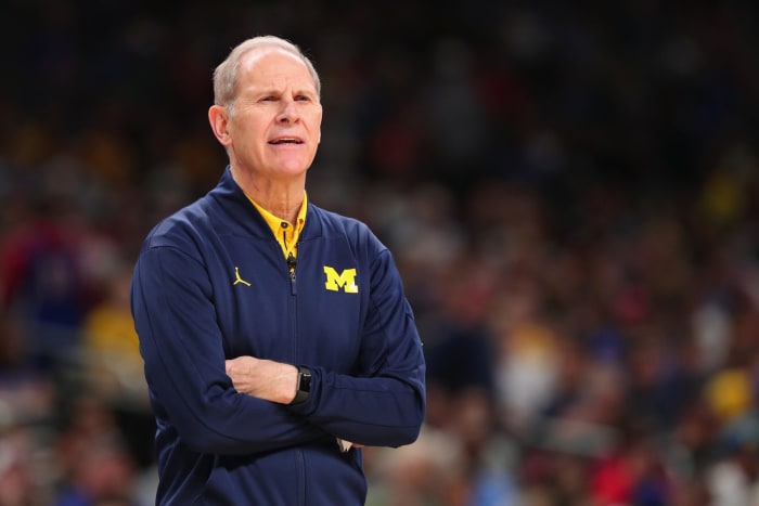 Michigan basketball head coach John Beilein crossing his arms while wearing a Michigan jacket.