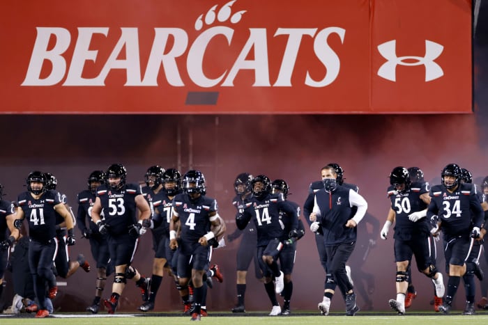 Cincinnati's players take the field against East Carolina.