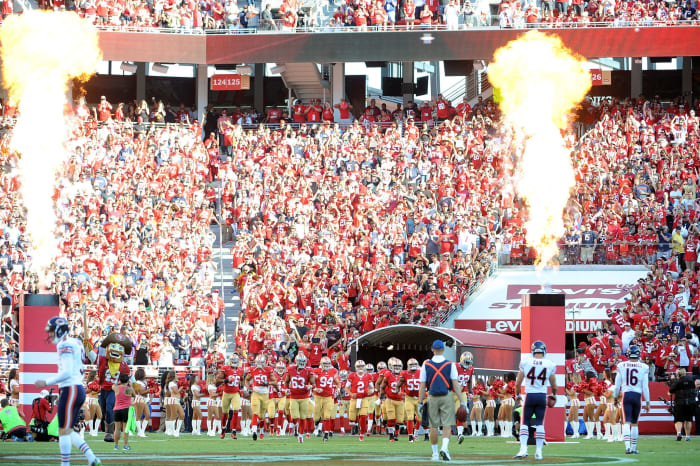 San Francisco 49ers players running onto the field.