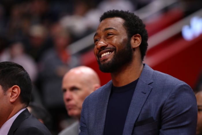 John Wall sits on the bench during a game.