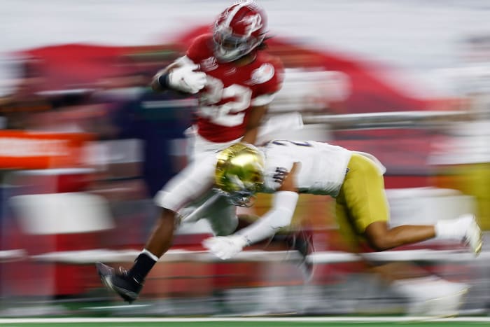 Najee Harris runs past a Notre Dame defender.