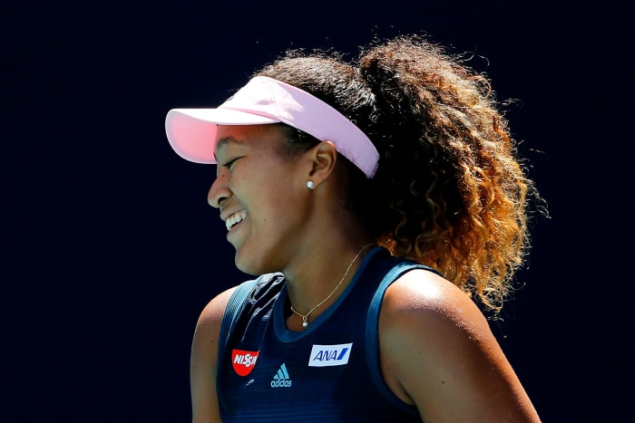 A closeup of Naomi Osaka smiling on the court.