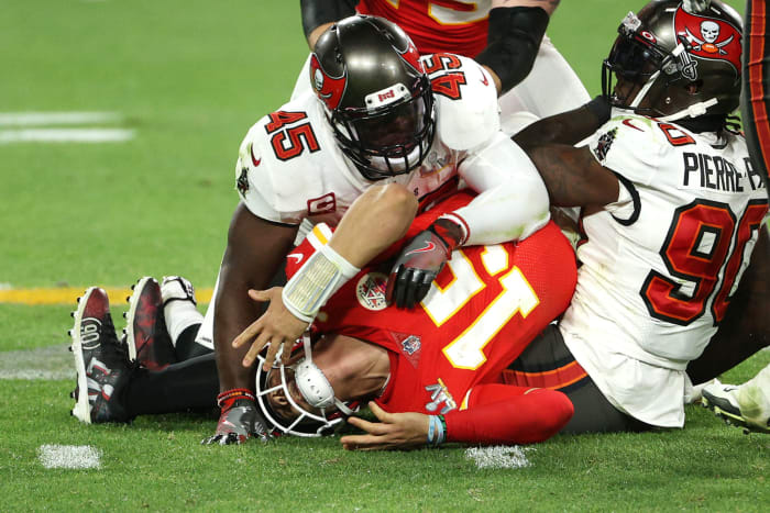 Patrick Mahomes lays on the ground with Devin White and Jason Pierre-Paul on top of him.