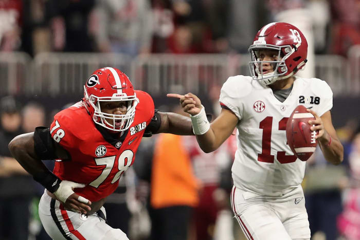 Quarterback Tua Tagovailoa #13 of the Alabama Crimson Tide scrambles with the football ahead of defensive tackle Trenton Thompson #78 of the Georgia Bulldogs.