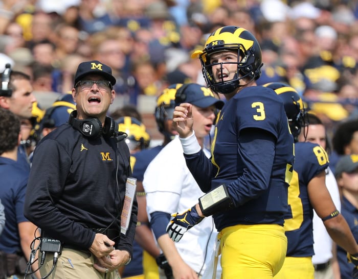 Michigan Wolverines head football coach Jim Harbaugh and starting quarterback Wilton Speight #3 watch the video replay during the first quarter of the game.