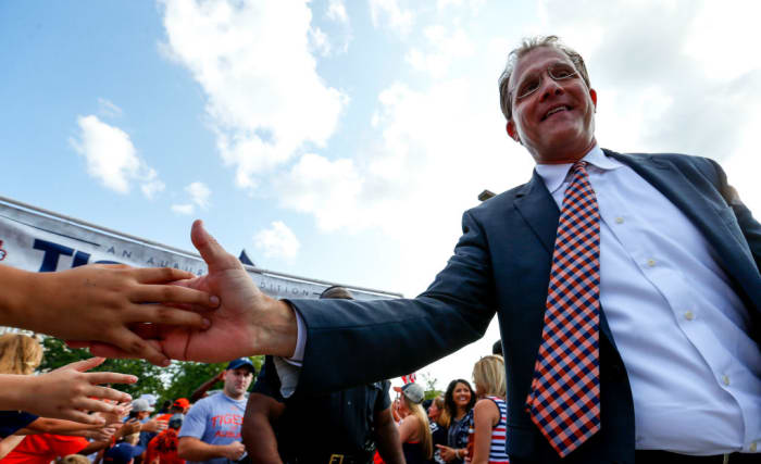 Gus Malzahn shakes fan's hands before a game.