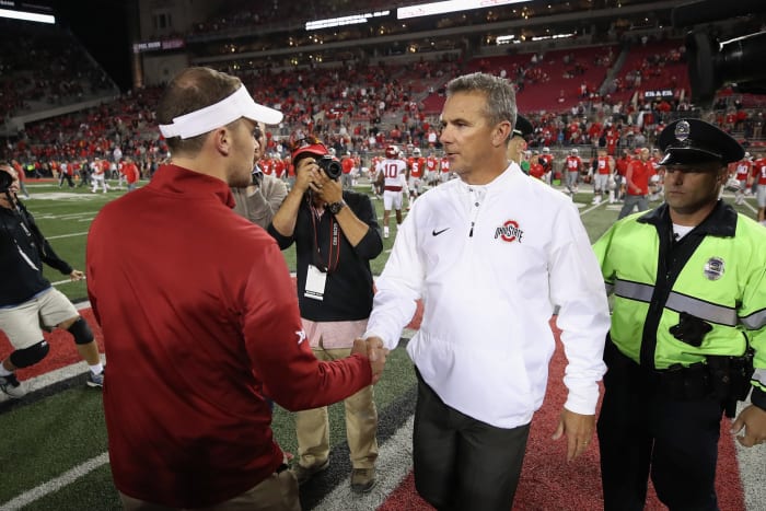 Urban Meyer shaking hands with Lincoln Riley after a game.
