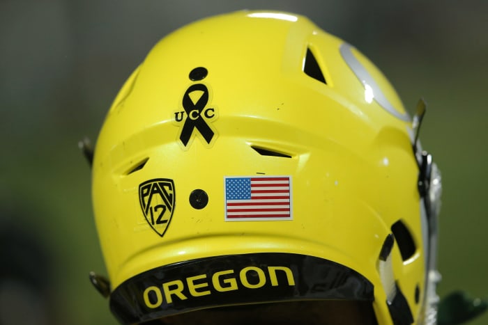 A closeup of a yellow Oregon helmet with a decal.