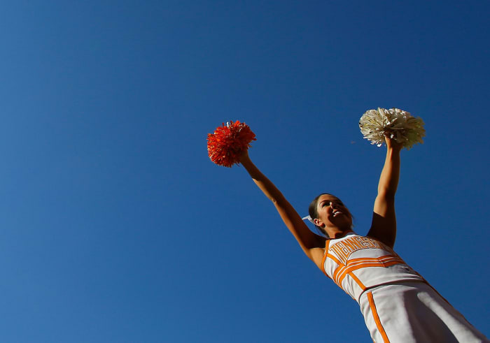 A Tennessee cheerleader with her hands in the air.