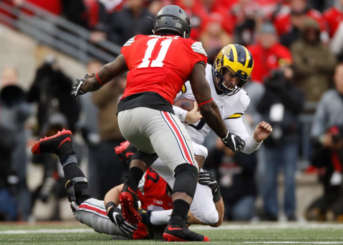 Ohio State players tackling Michigan's QB.