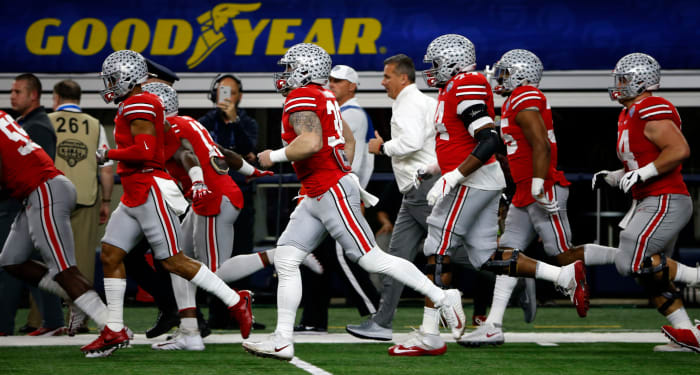 Ohio State football players running onto the field.
