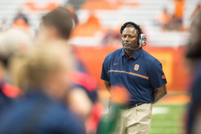 Dino Babers standing on the Syracuse sideline with his hands behind his back.