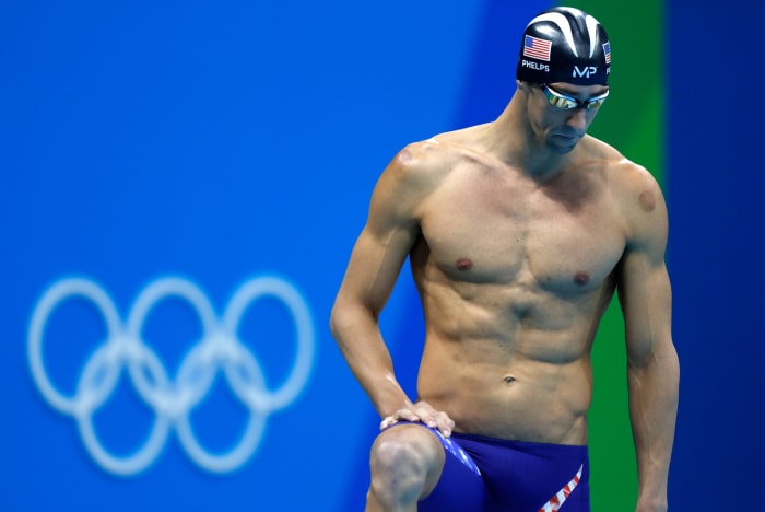 Michael Phelps preparing for a race with cupping marks on his body.