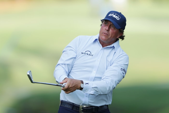 Phil Mickelson looking at his shot as it flies through the air.