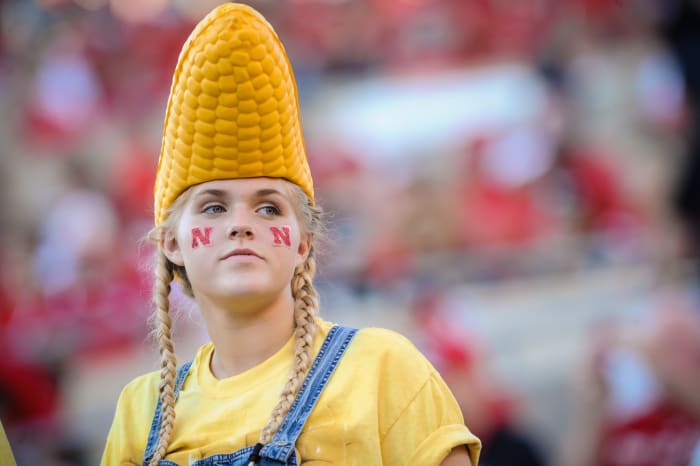 Nebraska fan with a husk of corn on her head.