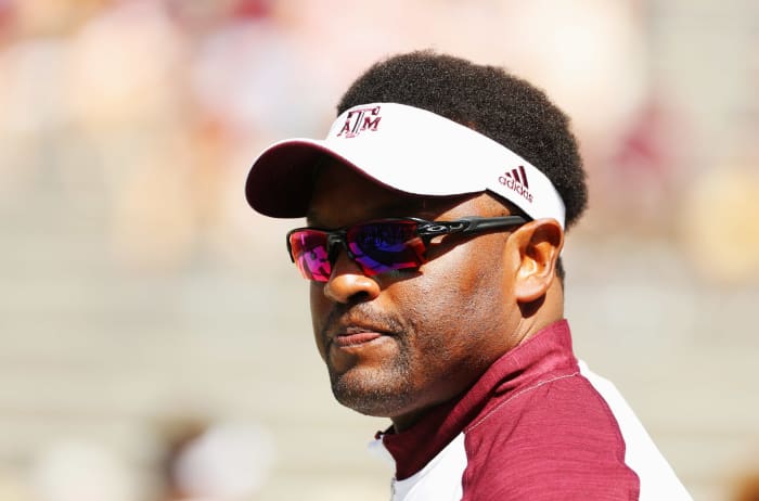 A closeup of Kevin Sumlin wearing a Texas A&M visor and sunglasses.