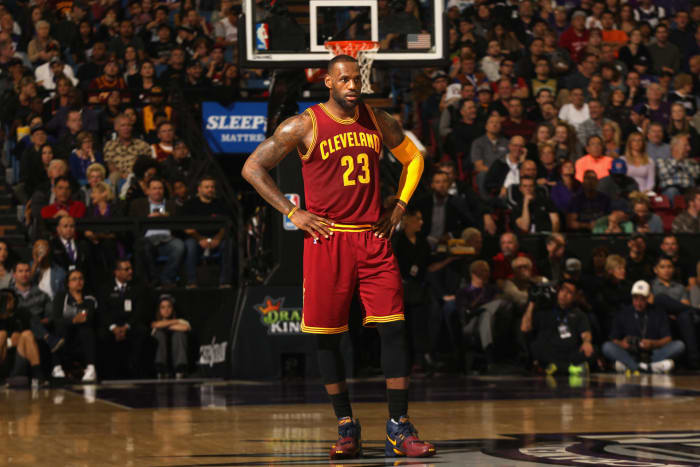 LeBron James standing at center court with his arms crossed.