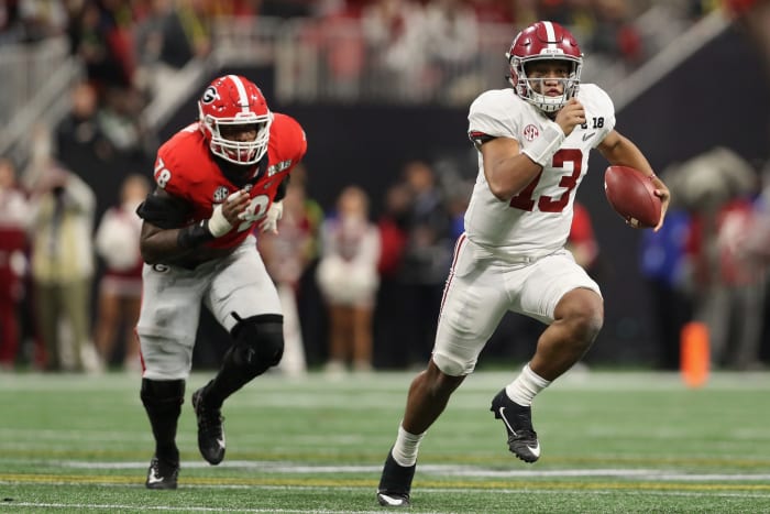 Quarterback Tua Tagovailoa of the Alabama Crimson Tide scrambles with the football ahead of defensive tackle Trenton Thompson #78 of the Georgia Bulldogs.