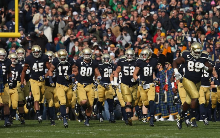 Notre Dame's football players running onto the field.