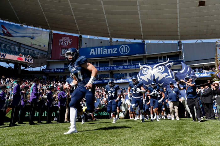Rice players running out of the tunnel.