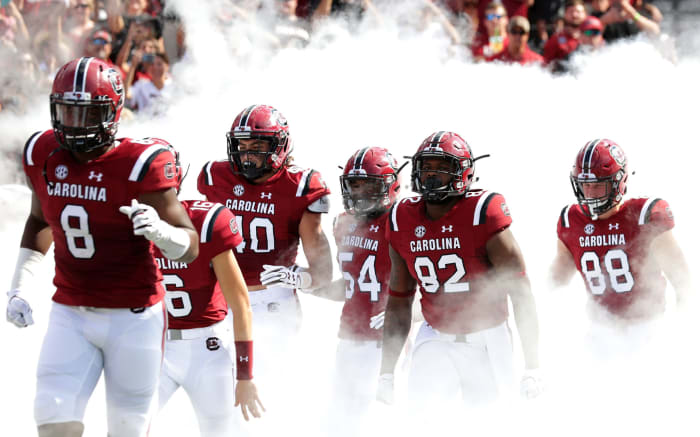 South Carolina football players run onto the field.