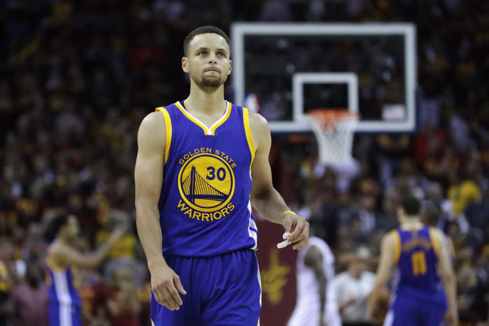 Stephen Curry holding his mouth guard in his left hand.