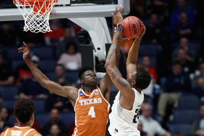 Mohamed Bamba of the Texas Longhorns blocks a shot by Jordan Caroline #24 of the Nevada Wolf Pack during the game in the first round of the 2018 NCAA Men's Basketball Tournament.