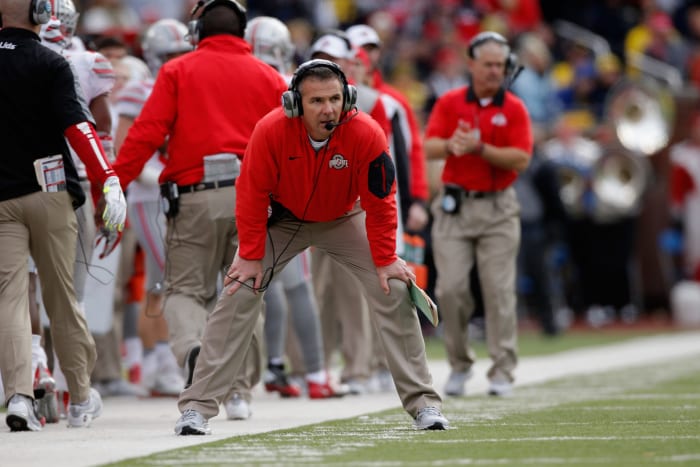 Urban Meyer crouching on the Ohio State sideline.