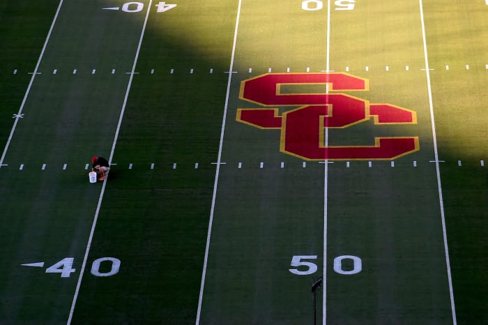 A worker painting the lines on USC's football field.