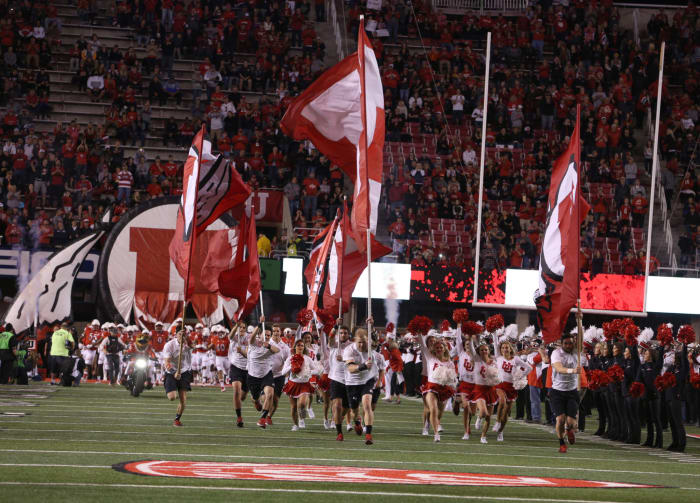 Utah's football team being led onto the field.