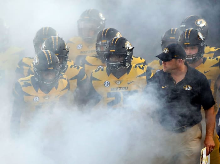 Missouri football players running onto the field.