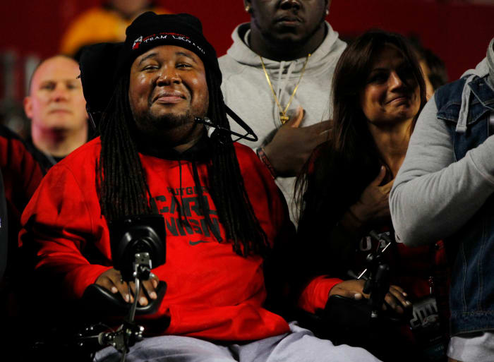 Erik Legrans in his wheel chair while wearing a Rutgers football shirt.