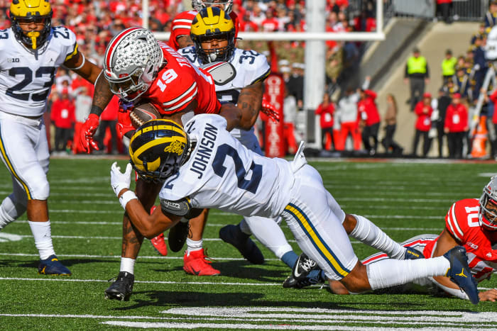 Michigan's Will Johnson tackles an Ohio State player running with the ball.
