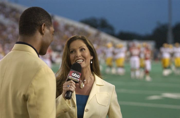 CANTON, OH - AUGUST 4: ABC's Monday Night Football sideline reporter Lisa Guerrero interviews Pro Football Hall of Fame enshrinee Marcus Allen during the Hall of Fame game between the Green Bay Packers and the Kansas City Chiefs at Fawcett Stadium on August 4, 2003 in Canton , Ohio.  The Chiefs held a 9-0 lead when the game was called due to unsuitable weather conditions.  (Photo by David Maxwell/Getty Images)